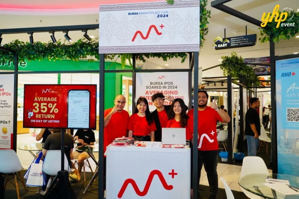 Bursa Marketplace Fair 2024: Sarawak Edition 25 M+ Online team in red shirts posing at their investment booth