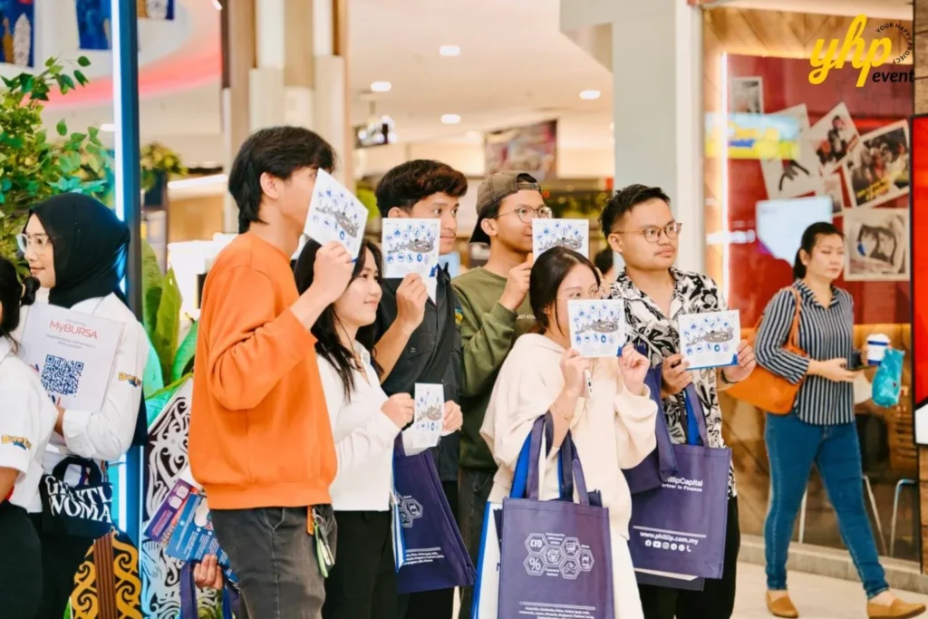 Bursa Marketplace Fair 2024: Sarawak Edition 9 Young visitors hold up informational brochures and gift bags at the Bursa Marketplace Fair 2024 event
