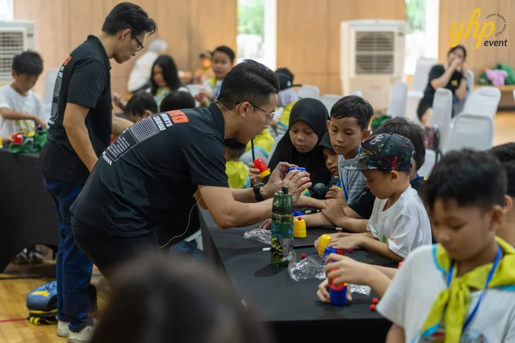 Super Kids Explorer: An Exciting Adventure at Bukit Bantayan 16 An instructor helps a group of children assemble a mechanical project at a robotics workshop