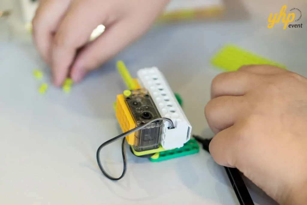 Super Kids Explorer: An Exciting Adventure at Bukit Bantayan 17 Extreme close-up of a child's hands connecting wires and sensors for a robotics workshop task