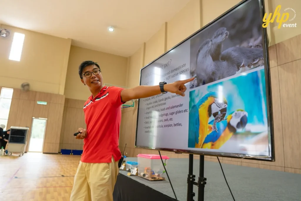 Super Kids Explorer: An Exciting Adventure at Bukit Bantayan 20 A male speaker points at a screen showing otters and parrots
