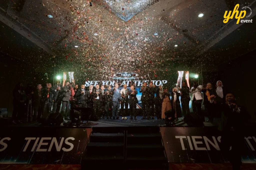 TIENS Sabah Convention l Borneo Royale Hotel Tawau 11 Confetti falls over TIENS attendees gathered onstage during a celebration moment beneath dramatic event lighting