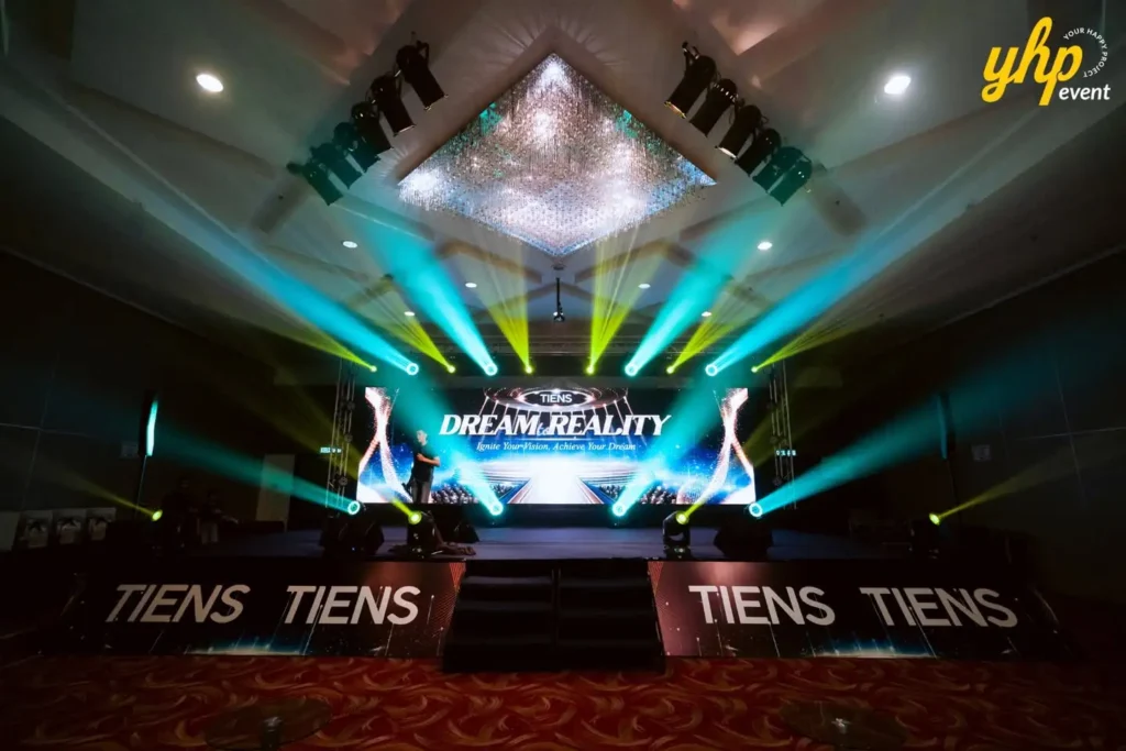 TIENS Sabah Convention l Borneo Royale Hotel Tawau 12 TIENS Dream Reality stage glows with blue and yellow beams beneath chandeliers in an empty ballroom