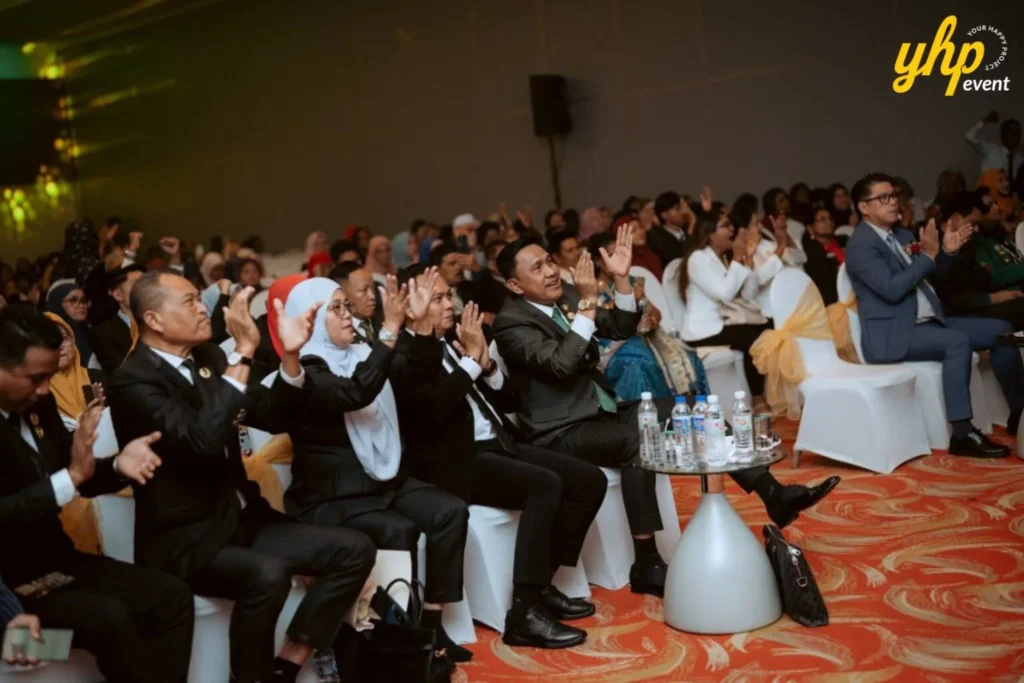 TIENS Sabah Convention l Borneo Royale Hotel Tawau 9 Seated TIENS attendees applaud during the program while watching the stage from the front seating area