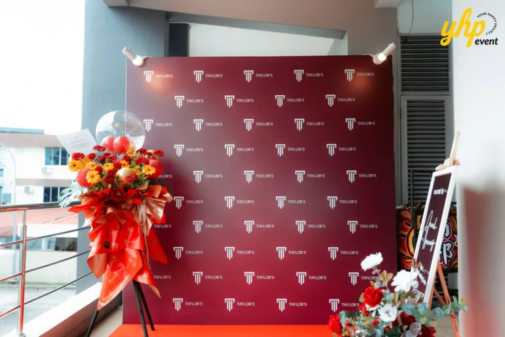 Grand Opening of Taylor's Sabah Counseling Centre 3 Maroon branded backdrop with Taylor's logos and floral arrangement for Education Counseling Centre event