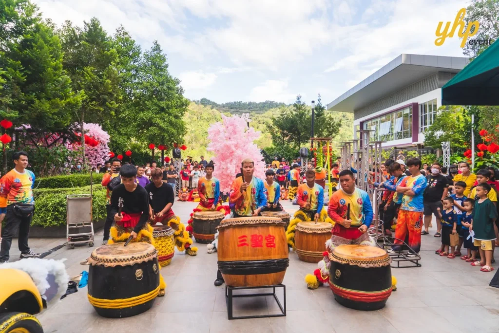 #TooHuattoHandle Lunar New Year Celebration 2 Traditional Chinese drum performance at a community festival, with lion dancers, spectators, and pink blossom decorations