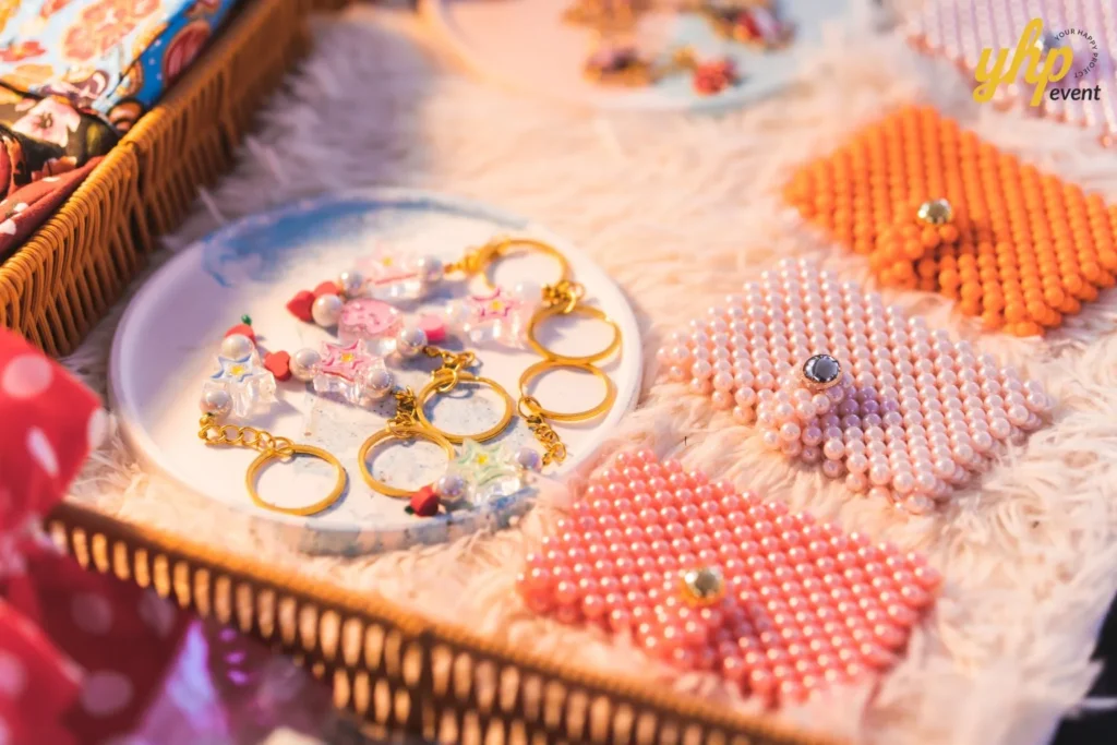 #TooHuattoHandle Lunar New Year Celebration 15 Handmade beaded purses and pastel charm keychains displayed on a soft fabric tray at a craft market stall