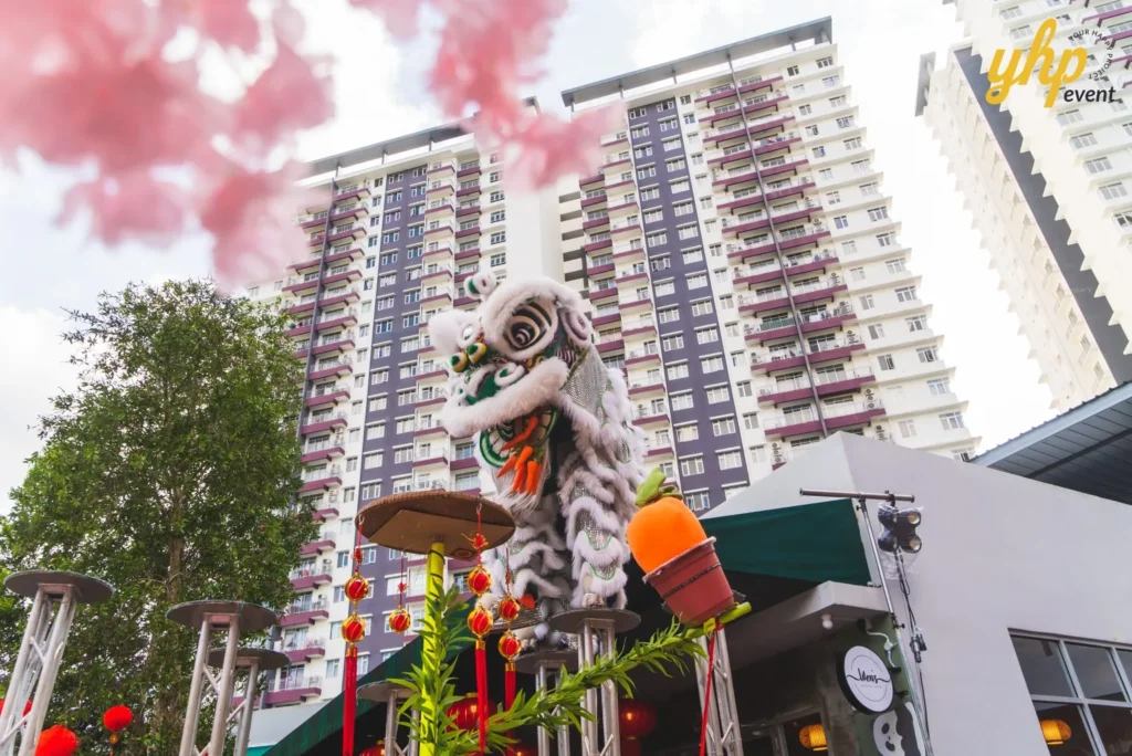#TooHuattoHandle Lunar New Year Celebration 5 White lion dance performer balanced on high poles in front of apartment towers during an outdoor festive showcase