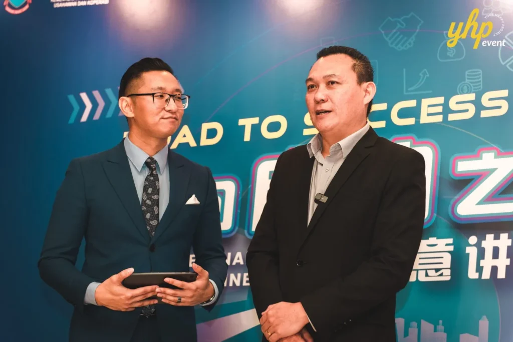 Empowering Entrepreneurs: YPPKM Small Business Seminar in Kota Kinabalu 13 Two business professionals in suits discuss entrepreneurship at the YPPKM road to success seminar